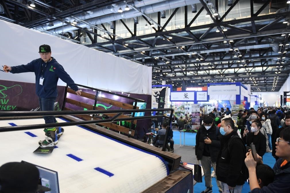 2023年2月11日，參觀者在展會上了解一款模擬滑雪設(shè)備。當(dāng)日，2023亞洲運(yùn)動用品與時尚展在國家會議中心拉開帷幕。新華社記者 張晨霖 攝