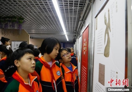 圖為學生參觀青海省博物館“1+3”主題流動展覽，了解木舞俑。中新社記者 馬銘言 攝