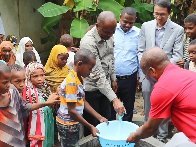 在日前舉行的安全供水工程揭牌儀式上，當(dāng)?shù)匦∨笥言诠┧c(diǎn)接水。 施亮攝