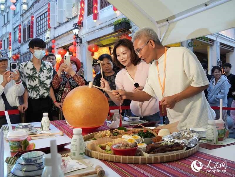 嘉賓品嘗海南傳統(tǒng)美食“煎堆”。人民網(wǎng)記者 張力洋攝