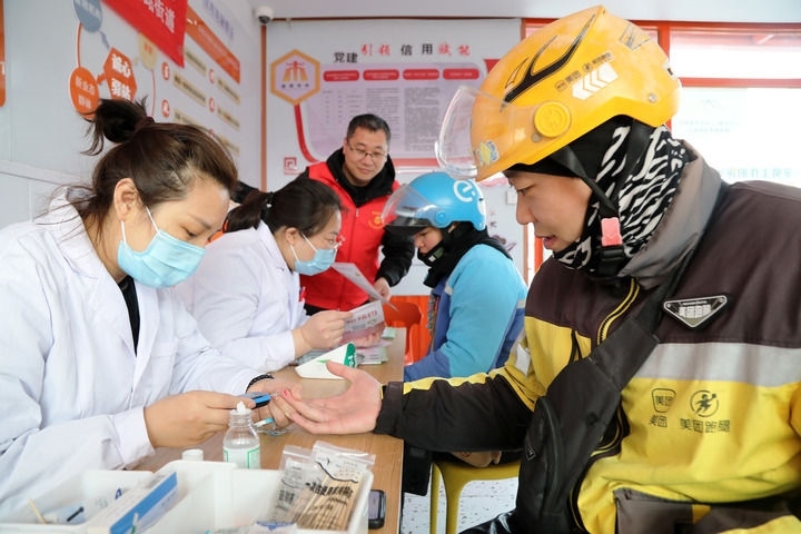 2025年3月5日，志愿者在山東省棗莊市市中區(qū)一工會驛站為外賣員免費測量血糖。新華社發(fā)（王海楠攝）