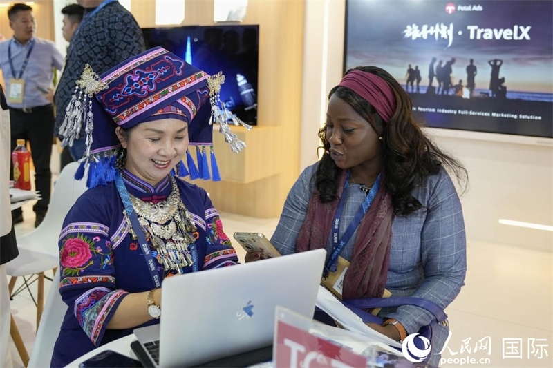 來自廣西的旅游業(yè)者同客戶交流。人民網(wǎng)塔里克·易卜拉欣攝