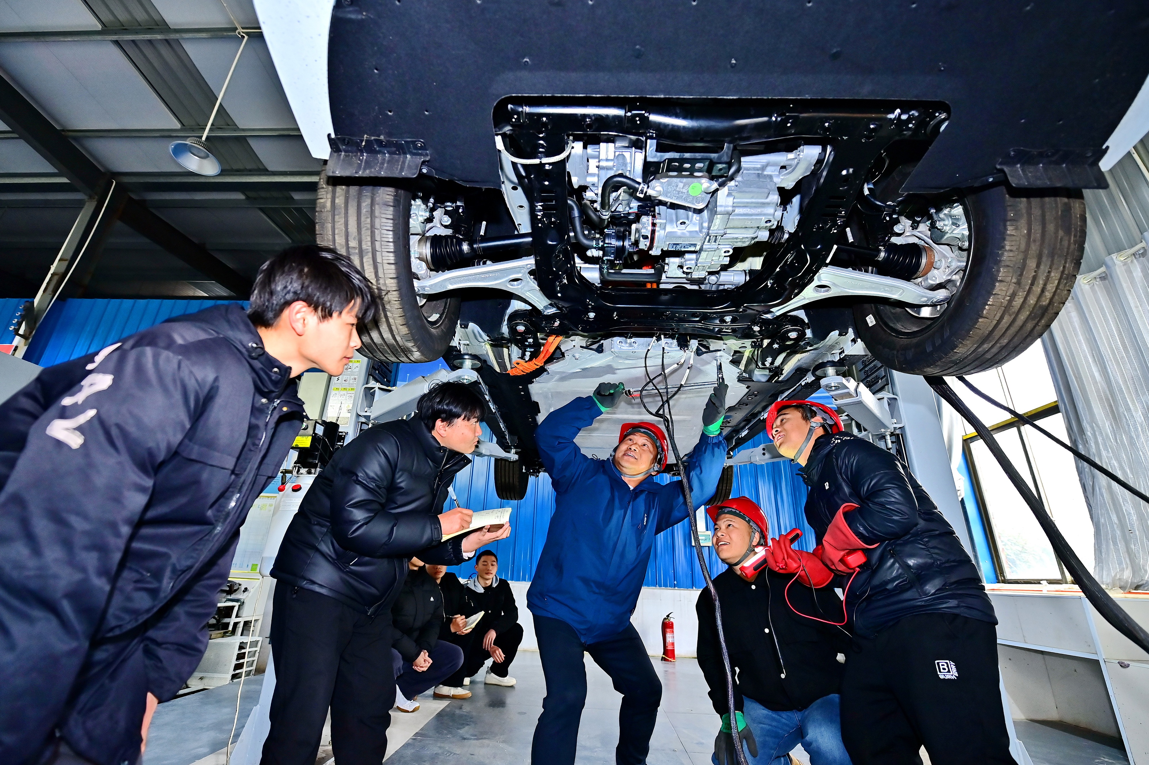 2025年2月，江西省宜春市，豐城市的一所技工學(xué)校實(shí)訓(xùn)基地內(nèi)，新能源汽車運(yùn)維專業(yè)學(xué)生在老師的指導(dǎo)下學(xué)習(xí)新能源汽車電池包檢修技術(shù)。