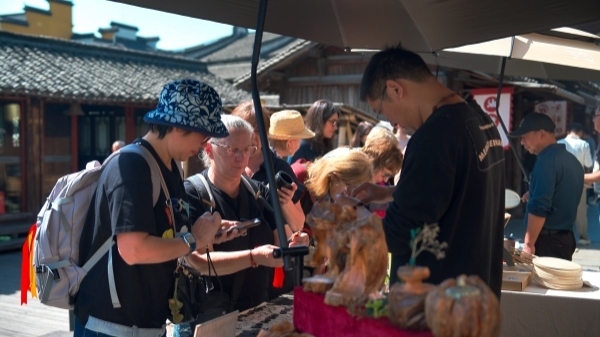 “五一”期間，游客正在烏鎮(zhèn)“水鄉(xiāng)碼頭”挑選購買文創(chuàng)產(chǎn)品。受訪者供圖