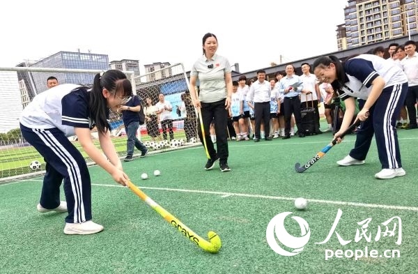 陳朝霞（中）指導(dǎo)學(xué)生體驗(yàn)曲棍球。 人民網(wǎng)記者 楊磊攝