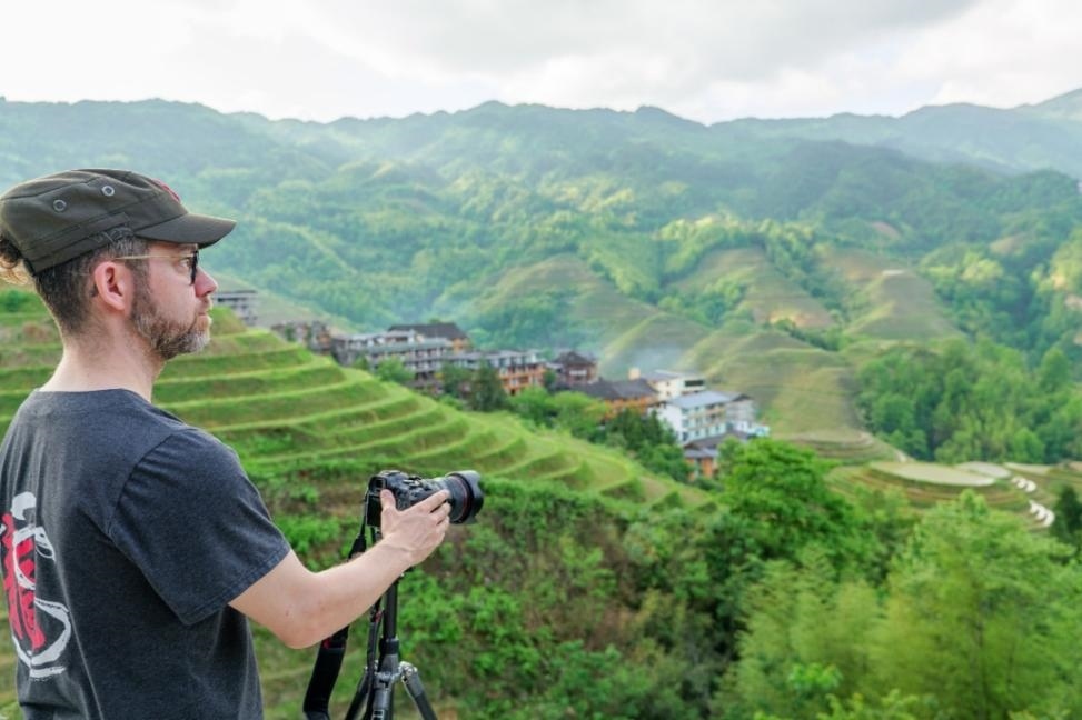 2025年年5月9日，廣西桂林，外國(guó)游客游覽龍脊梯田，在美景前駐足拍照。（圖片來源：視覺中國(guó)）