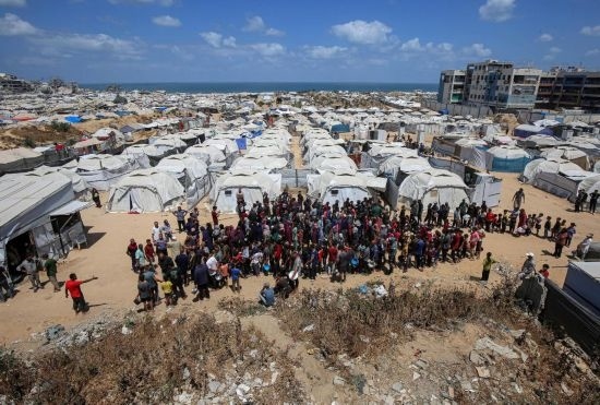 5月28日，人們在加沙城西部的沙提難民營等待領取救助食物。新華社發(fā)（里澤克·阿卜杜勒賈瓦德攝）