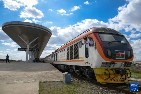 5月31日，在蒙內(nèi)鐵路內(nèi)羅畢站，機車駕駛員蔣立平（右）和博爾在即將開往蒙巴薩的E2次列車上揮手致意。新華社記者 楊光 攝