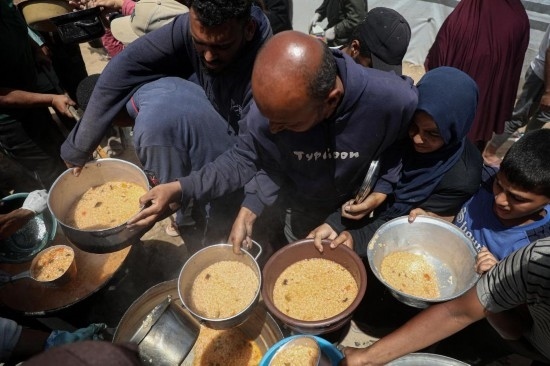 5月28日，人們在加沙城西部的沙提難民營領取救助食物。新華社發(fā)（里澤克·阿卜杜勒賈瓦德攝）