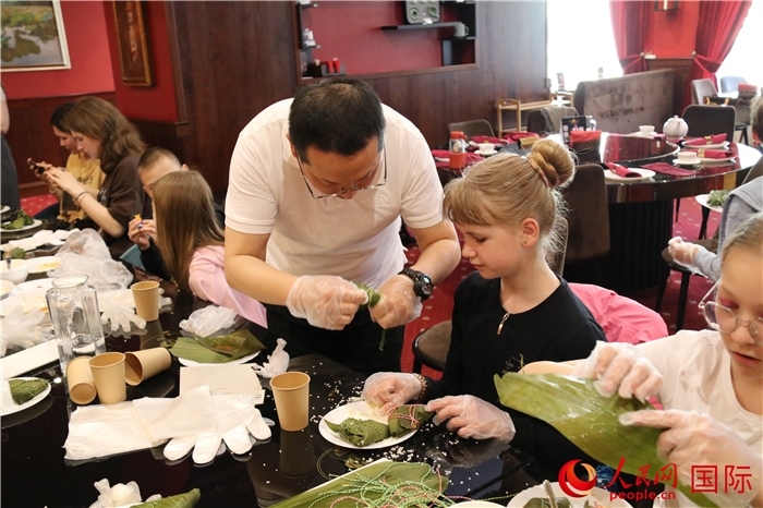 烏克蘭兒童學(xué)習(xí)體驗包粽子。人民網(wǎng)記者蔡子暢攝
