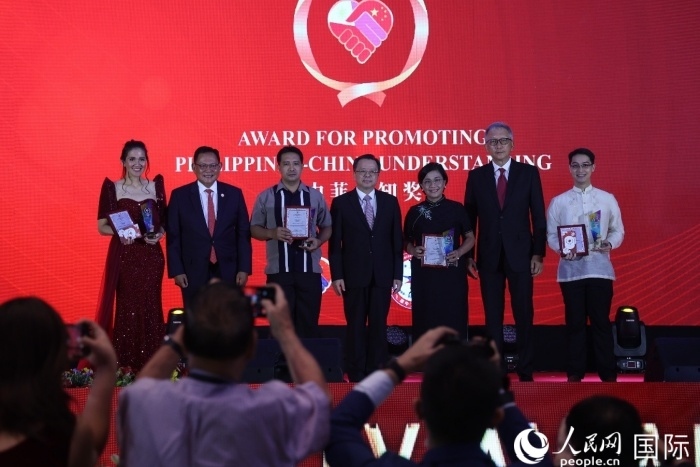 黃溪連大使和菲中了解協會主席與榮獲“友誼獎”的獲獎者合影留念。人民網記者 樊帆攝